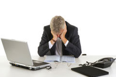 ¿Qué LASTRA la productividad? Un señor sentado en una mesa agobiado.