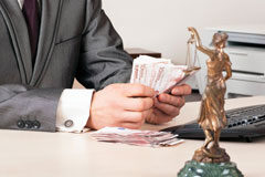 El salario mínimo como límite para el abono de la responsabilidad civil. A propósito de la interesante STS 230/2018, de 2 de febrero Un abogado con unos billetes en las manos.