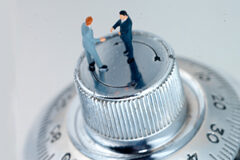 Colaboración entre Logalty y el Colegio de Administradores de Fincas de Madrid 2 figuras de hombres encima de la rueda de una caja de seguridad