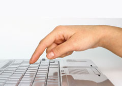 Un dedo tocando un teclado de ordenador.