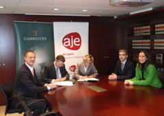 Juan Luis Falcón y Pilar Andrade firman el convenio de colaboración, acompañados por varios profesionales de Garrigues y AJE Aragón