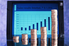Un buen software de gestión aumenta la posibilidad de crecimiento rentable en una empresa En un portátil un gráfico y encima de la mesa monedas apiladas imitando al gráfico