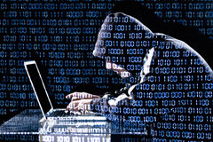 El impacto económico de la ciberdelincuencia Una persona encapuchada con un portátil