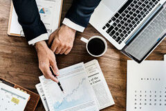 ¿Hasta qué punto puede influir el nombre de tu despacho en el posicionamiento online? Persona con calculadora y gráficos