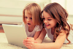 Los riesgos de las nuevas tecnologías en los menores Dos niñas mirando un portátil