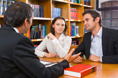 ¿Podemos implantar los abogados una cultura de servicio al cliente? Están en un despacho el abogado y en frentes sus clientes (una mujer y un hombre)