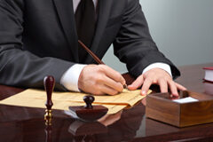 El despacho atiende al cliente, pero el abogado no Un abogado firmando un documento
