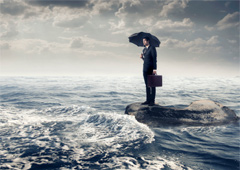 Persona con paraguas y maletín en medio del mar