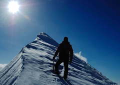 Persona escalando una montaña nevada