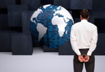 La normativa anticorrupción extiende su ámbito a países como Brasil. ¿Cuál puede ser la implicación para empresas españolas? Un hombre esposado frente a una bola del mundo