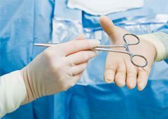Manos de cirujanos pasando las tijeras