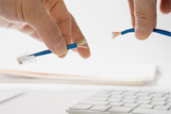 Responsabilidad por corte de línea telefónica de despacho de abogado Dos manos sujetando el cable cortado de un teléfono