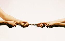 Entrecruce de intereses Dos personas tirando de una cuerda, cada una para su lado.
