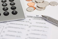 Declaración del Impuesto sobre Sociedades 2010 Una calculadora, un boli, y unas monedas sobre unos papeles