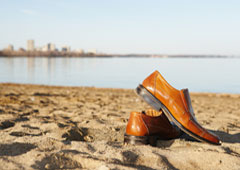 Un par de zapatos marrones sobre la arena.