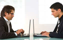 ¿Por qué implantar un sistema de calidad en un despacho? Dos personas con portatil en un despacho