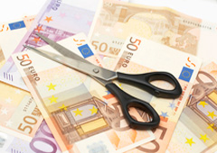 Unas tijeras encima de billetes de euro