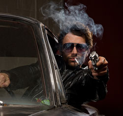 Hombre montado en un coche apuntando con una pistola