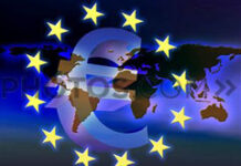 Primacía del Derecho tributario comunitario Símbolo del euro sobre mapamundi