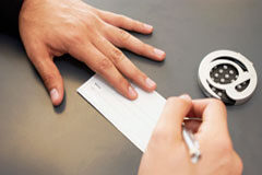 Rigor cambiario: la letra de cambio sin mención del tomador no es letra. Una persona firmando un cheque.