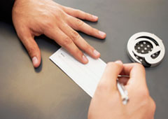 Una persona firmando un cheque.