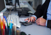 Los nuevos grupos fiscales en el IS Una persona manejando una calculadora