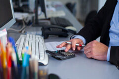 Los nuevos grupos fiscales en el IS Una persona manejando una calculadora