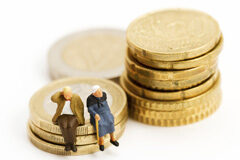 Jubilación no contributiva: el certificado de empadronamiento es válido para acreditar el requisito de residencia Dos muñecos de ancianos sentados sobre montoncitos de euros