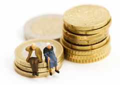 Dos muñecos de ancianos sentados sobre montoncitos de euros