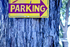 Parking en verano, pero tributa como si lo fuera todo el año Un letrero de 'parking' colocado en el tronco de un árbol