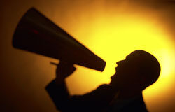 ¿Puede considerarse que el acuerdo alcanzado por un sindicato con la empresa, sin participación de los demás sindicatos, vulnera la libertad sindical de estos últimos? hombre gritando por un megáfono