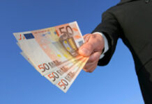 Sobre la (cada vez menor) eficacia liberatoria del finiquito Una mano con billetes de 50 euros