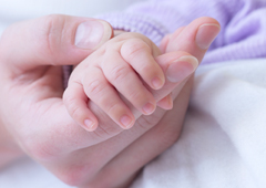 La mano de una madre agarrando la mano de su bebé