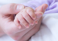 La mano de una madre agarrando la mano de su bebé La mano de una madre agarrando la mano de su bebé