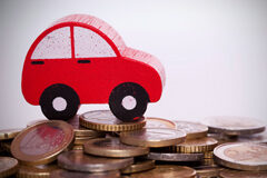 Sobre la afectación de los elementos patrimoniales de un abogado, y contribuyente, a su actividad económica y/o a sus necesidades privadas Monedas apiladas y arriba un coche de madera de juguete