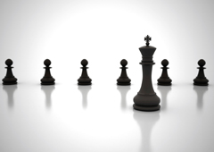Unas piezas de ajedrez 'peones' en fila y en frente la pieza de ajedrez 'El rey'