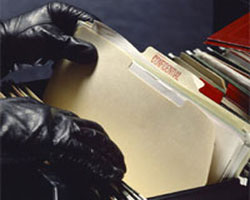 Unas manos rebuscando en un cajón lleno de archivos privados.