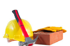 Deducción por obras de Mejora en la Vivienda Un casco amarillo, guantes, un martillo y un ladrillo.