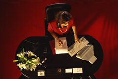 La secretaria del despacho, nuestro mejor cliente Una secretaria en su mesa con el ordenador