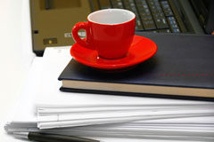Toga y teletrabajo: una pareja cada vez menos extraña Un portatil, unos foleos y una taza roja.