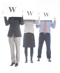 Tres personas sujetando cada uno un cartel con un dibujo de la letra w