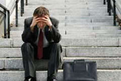 Despido improcedente y no nulo: no hubo mobbing Un abogado con las manos en la cabeza sentado en unas escaleras derrotado.