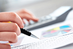 La responsabilidad de los administradores de sociedades mercantiles (I) Alguién haciendo cuentas con una calculadora y se ve un papel con gráficos y otro con cuentas