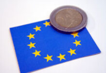 El nuevo “single market tax” Una moneda de euro encima de una bandera de la UE