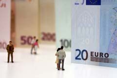 ¿Cómo calculan los jueces la pensión alimenticia qué debe pagar el progenitor custodio? billetes de 20 y 50 euros colocados en pie y muñequitos mirándolos