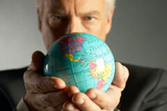 El papel del asesor legal como figura clave en el proceso de internacionalización de la empresa Un hombre de traje sujetando una bola del mundo