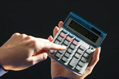 Rebajas Fiscales de última hora Una mano tecleando en una calculadora.