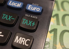 Unos billetes de 50 euros al lado de una calculadora donde en una de las teclas pone TAX más y en otra TAX menos