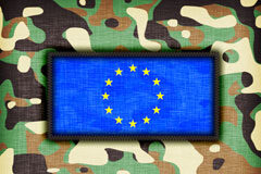 Pasos firmes hacia la unión de la defensa: la Cooperación Estructurada Permanente (PESCO) del Tratado de Lisboa ve la luz Bandera UE rodeada de dibujos de camuflaje