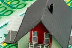 Contratos de crédito inmobiliario: adaptación del derecho español al comunitario Una casita sobre billetes de 100 euros